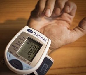 Mão de uma pessoa com aparelho de medir a pressão sanguínea